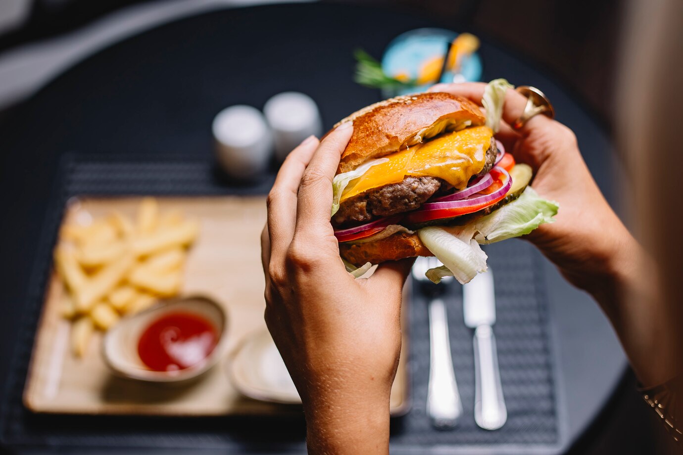 mujer sostiene hamburguesa ternera lechuga tomate cebolla roja queso cheddar 141793 2204
